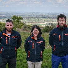 Trois ambassadeurs de tri devant un paysage breton