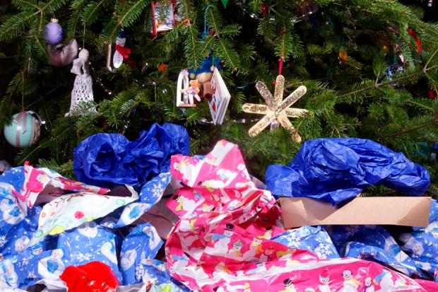 Au pied d'un sapin de Noël, des déchets d'emballages en papier cadeaux